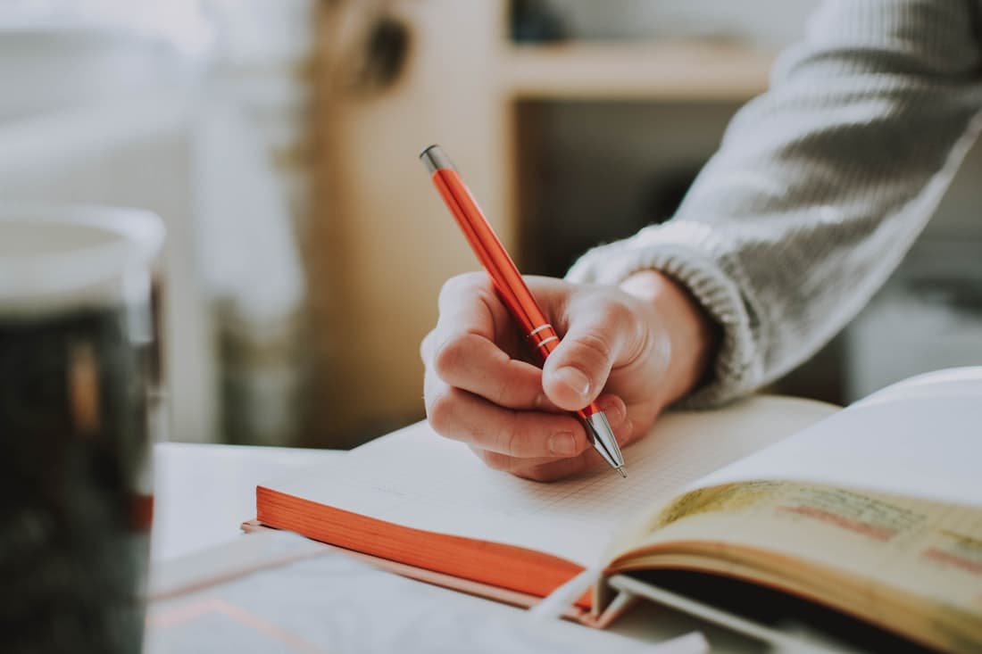 Hands working through research notes at a desk